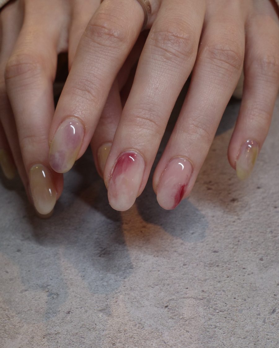 赤とライムをにじませた、透けるニュアンスネイル